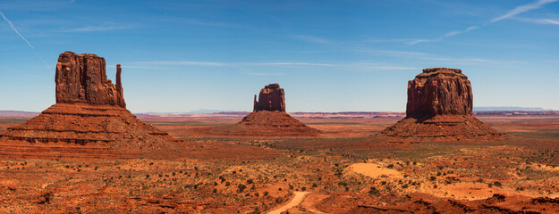 Monument valley landscape, Utah, USA. The west and east Mitten, Merrick Butte . clear blue sky, dirt road passing infront, desert landscape