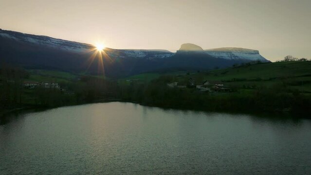 Monta&ntilde;as nevadas iluminadas por el sol sobre el lago.