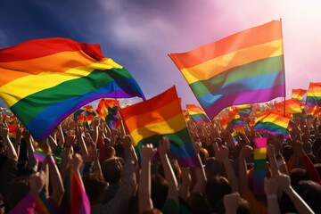 A crowd waving rainbow flags in the air, representing the LGBT community