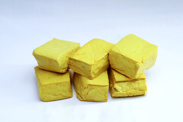 yellow tofu boxes stacked and isolated on white background. Foods high in vegetable protein are good for vegetarians.