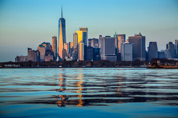 Fototapeta na wymiar Manhattan from upper Bay at sunset with light reflection in towers, New York