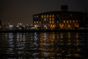 Red Hook old pier buildings with night lights and reflection in water, Brooklyn, New York