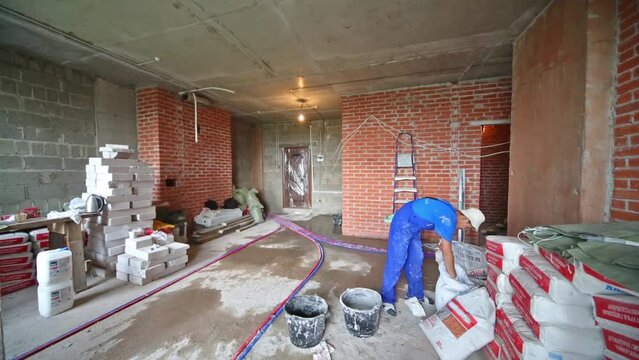 Worker is mixing in the buckets some compo on room.