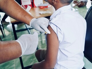 Prevent vaccination , close up doctor holding syringe and using cotton before make injection to Vaccinate students. - obrazy, fototapety, plakaty