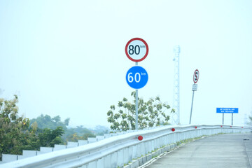 Speed ​​limit and minimum speed signs on Indonesian toll roads. The maximum speed limit is 80 km per hour and the minimum speed is 60 km per hour.