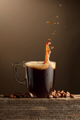 Espresso coffee glass cup with splashes on a brown background.