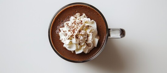 Top view of a white background with a glass cup of tasty hot chocolate topped with whipped cream. - Powered by Adobe
