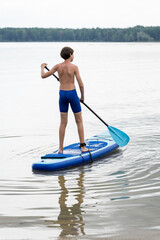 Teenager and SUP board. Active recreation on the Senftenberg lake. Federal land of Brandenburg....