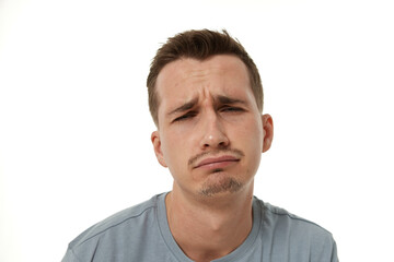 Obraz premium Portrait of offended frustrated young man on white background. sadness
