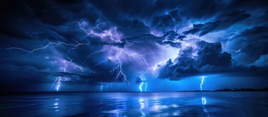 Fototapeten Intense lightning at night, above water. © AkuAku