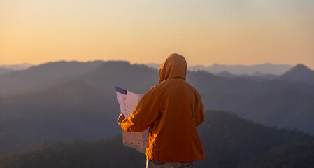 Traveller is looking at map for direction while exploring wildlife in the mountain area for...
