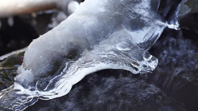 Close up of water flowing down a ice covered stream in Laterns, Austria