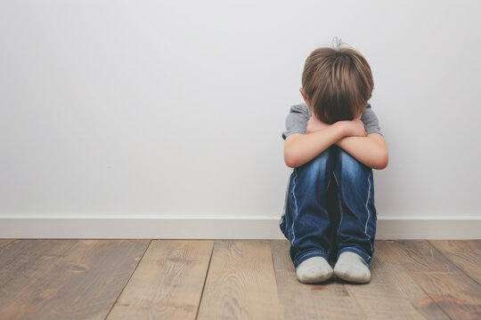 scared and depressed child sitting on the floor