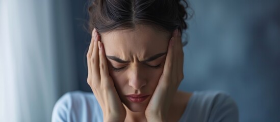 Stressed pregnant woman in her 30s experiencing migraines.