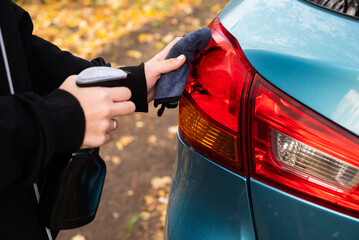 Car disinfection service. A woman disinfects and cleans the inner handle of the car door. Safety...