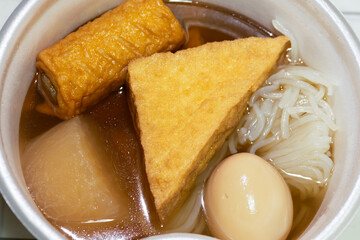 Oden - a Japanese winter food served in a styrofoam bowl from the convenience store in Japan. Close up shot.