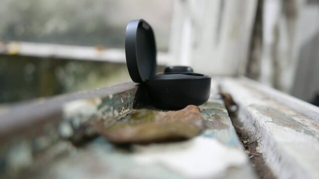 Putting Bluetooth headphones in the charging case. Person placing headphones in the charger. Music device. Charging headphones battery. Using an earphone charger. Charging earphones. Headphone charger