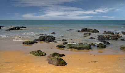West Africa, Senegal. The sandy beach of the resort area is surrounded by rocks and fragments of...
