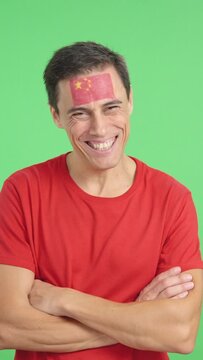Man standing with chinese flag painted on face smiling