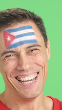 Man with a cuban flag painted on the face smiling