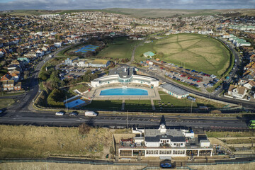 Aerial view of the Saltdean art deco Lido and the WhiteCliffs Saltdean Cafe on the seafront in East Sussex, Southern England with the South Downs in the background.