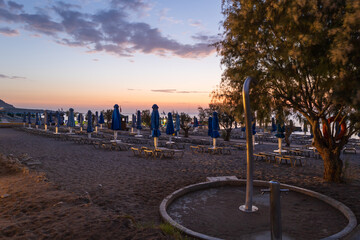 Beach by the sea on the island of Rhodes in Greece. Parasols and sunbeds on the beach.