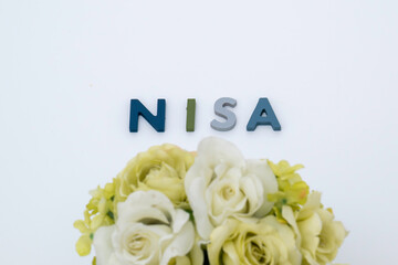 NISA少額投資非課税制度のテキストと花