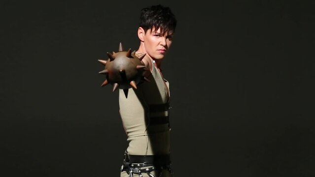 Handsome young man in medieval hunting costume swings his mace