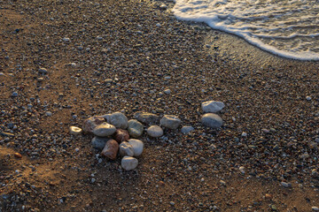 The waves of the sea wash the shore of the pebble beach.