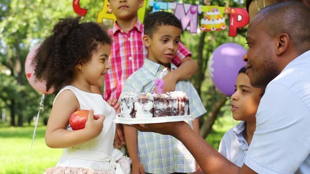 Little girl blows out candle on celebration of her third birthday