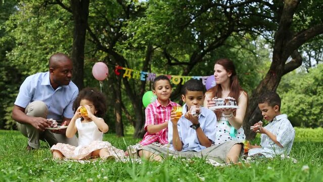 Birthday party, family eating cake in the park 