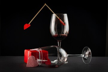 glasses with red wine, gift box and cupid's arrows