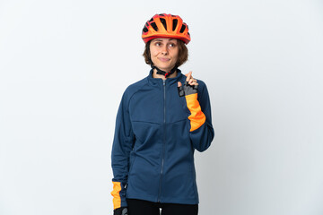 Young English cyclist woman isolated on white background with fingers crossing and wishing the best