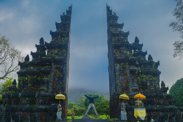a man jumping on bali handara gate, bali