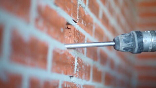 Moving big perforator breaking brick wall in apartment