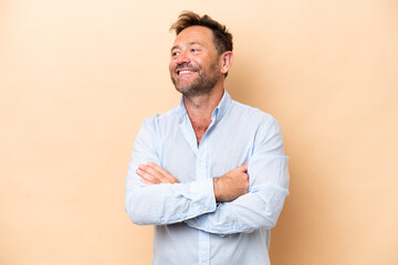 Middle age caucasian man isolated on beige background happy and smiling