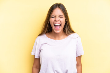 Fototapeta premium Young caucasian woman isolated on yellow background shouting to the front with mouth wide open
