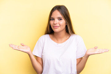 Young caucasian woman isolated on yellow background having doubts