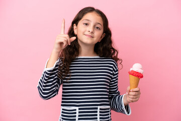 Little caucasian girl holding an ice cream isolated on pink background pointing up a great idea