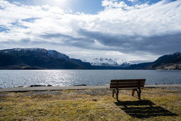 Naklejka na ściany i meble Lonely bench at the cold Norwegian fjord