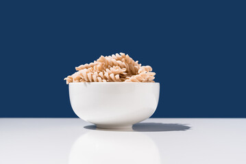 Espirales de pasta. Macarrones de trigo orgánico sobre fondo azul	