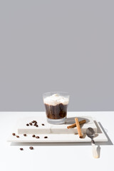 Café irlandés con crema batida y canela sobre fondo gris
