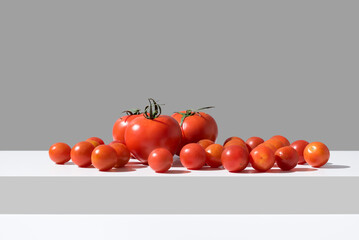 Tomates maduros frescos variados sobre fondo gris	