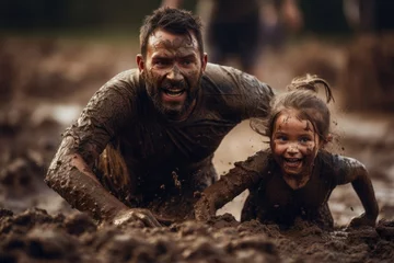 Fotobehang father and daughter covered in mud crawl determinedly during a mud run, faces alight with fierce joy and the thrill of the challenge, blurred background © gankevstock