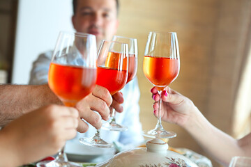 Closeup of four glasses with rose wine being clinked together