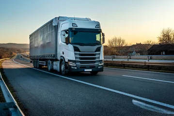 Foto op Plexiglas Big semi trailer truck on a highway driving at bright sunny sunset. Transportation vehicle © Ivan