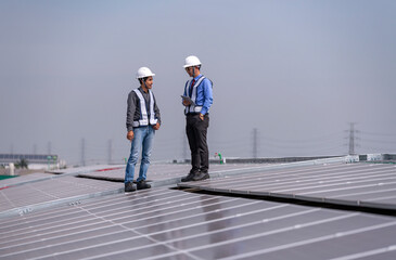 Engineers walking on roof inspect and check solar cell panel by hold equipment box and radio...