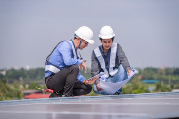 Engineers walking on roof inspect and check solar cell panel by hold equipment box and radio...