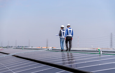 Engineers walking on roof inspect and check solar cell panel by hold equipment box and radio...