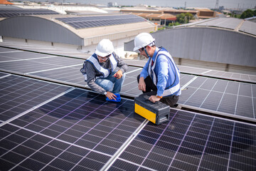 Engineers walking on roof inspect and check solar cell panel by hold equipment box and radio...